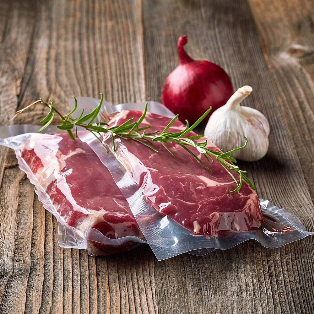 Fresh meat sealed in plastic vacuum pouches, with some seasoning displayed around it, indicating freshness.